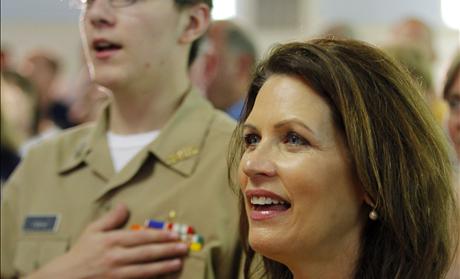 U.S. Congresswoman and likely Republican presidential candidate Michele Bachmann sings 'God Bless America' next to a current member of the U.S. Navy at an event to pay tribute to veterans on Memorial Day in Dover