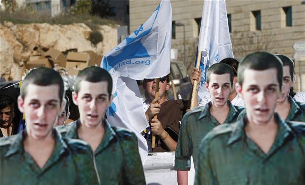 Israeli demonstrators holds flags behind cardboard cut-outs of captured Israeli soldier Gilad Shalit outside PM's office in Jerusalem