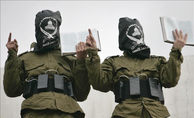Palestinian militants from al-Aqsa Martyrs Brigades hold copies of the Koran in Nablus