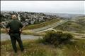 United States border patrol agent looks across the fence at Mexico as he patrols the U.S. border in San Ysidro, California,
