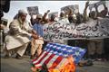 A man burns a mock U.S. flag during a rally to protest against U.S. special forces officer Raymond Davis in Lahore