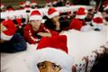 A boy clad in a Santa Claus hat looks on during a Christmas party in Miami.