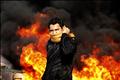 A protester stands in front of a burning barricade during a demonstration in Cairo